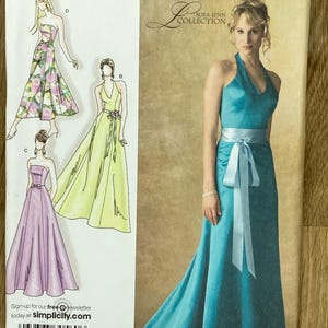 Könnte beinhalten: Simplicity Schnittmuster für Abendkleider. Das Schnittmuster zeigt Illustrationen verschiedener Kleidungsstile, darunter ein türkisfarbenes Neckholder-Kleid mit fließendem Rock und einem hellblauen Schärpe. Die Größe des Schnittmusters ist RS 14, 16, 18, 20, 22.