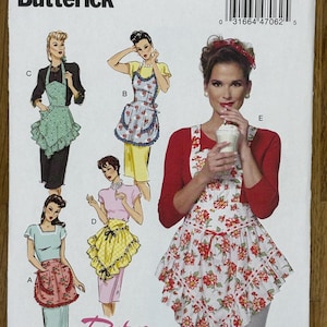 May include: A sewing pattern for a retro-style apron with four different designs. The pattern is for sizes small, medium, large, and extra large. The pattern is from Butterick and is number B6467.