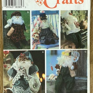 May include: Simplicity Crafts pattern showing Santa Claus dolls in different outfits. The image includes the number 9869, the words "ONE SIZE" and "by Faith Van Zanten". The dolls are dressed in various styles, including plaid, chef, and fishing attire.
