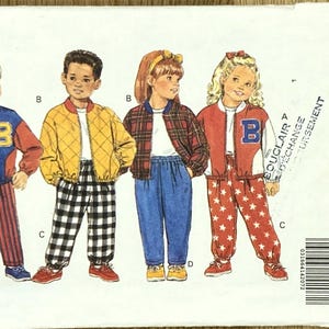 May include: Butterick 6296 sewing pattern featuring children's bomber jackets and pants. The jackets are red, blue, and yellow with various designs, including a letter "B" and star patterns. The pattern includes sizes 0/8.