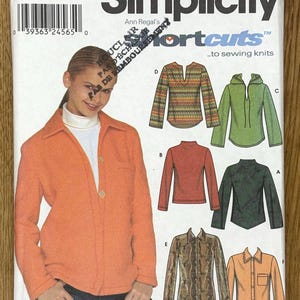 May include: Simplicity sewing pattern 9513 featuring six knitwear designs. The pattern includes a woman wearing an orange jacket. The pattern is for sizes 14, 16, 18, and 20. The text "6 made easy!" is visible.
