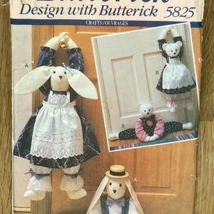 May include: A Butterick 5825 sewing pattern envelope featuring illustrations of stuffed fabric rabbits and bears. The rabbits wear dresses or overalls with hats and bows. The bears are shown in dresses with aprons or polka dot outfits.