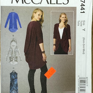 May include: McCall's sewing pattern M7441. The pattern features designs for a cardigan, hooded jacket, and dress. The cover shows a woman wearing a burgundy cardigan and black boots. The pattern includes size Y, (Xsm-Sml-Med).