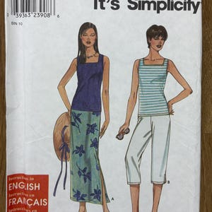 Può includere: Un modello di cucito intitolato "It's SO EASY it's Simplicity" presenta illustrazioni di due outfit. Uno include un top blu e una gonna floreale. L'altro include un top a righe e pantaloni capri bianchi. La taglia del modello è XS, S, M, L, XL.