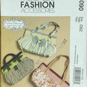 May include: A sewing pattern for three different handbags. The handbags are made of fabric with different patterns, including floral, gingham, and polka dots. The pattern is called "Artful Offerings" and is designed by Karina Hittle. The pattern number is M6090.