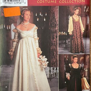 May include: Simplicity Renaissance Costume Collection sewing pattern. The pattern features three different Renaissance-style gowns. The main image shows a cream-colored gown with gold trim. The pattern includes sizes U 16, 18, and 20.