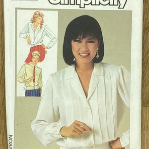 Könnte beinhalten: Simplicity Schnittmuster mit einer weißen Bluse mit vertikalen Falten und langen Ärmeln. Das Muster enthält Illustrationen der Bluse und das Simplicity-Logo. Die Mustergröße ist 8, Eur 36.