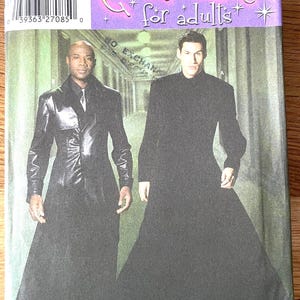 May include: Simplicity Costumes pattern for adults. The image shows two men modeling long black coats. The pattern number is 5386, with size options XS, S, M, L, and XL. The packaging has a purple and gold design.