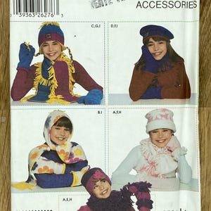 Può includere: Modello Simplicity Accessori con cappelli, sciarpe e guanti per bambini. Il modello include vari stili, come un cappello blu e giallo con sciarpa e guanti abbinati e un cappello floreale rosa e bianco.