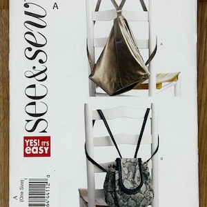 Può includere: Un modello di cucito intitolato "B5670" con due modelli di borse. Una è una borsa triangolare color oro metallizzato, e l'altra è una borsa con coulisse con un motivo a pelle di serpente. Il modello include il testo "see & sew" e "YES! It's easy."