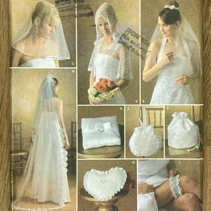 May include: Simplicity sewing pattern 4216 featuring bridal wear. The pattern includes designs for wedding dresses, veils, ring pillows, a drawstring bag, and a heart-shaped pillow. The pattern is size A, all sizes. The website is simplicify.com.
