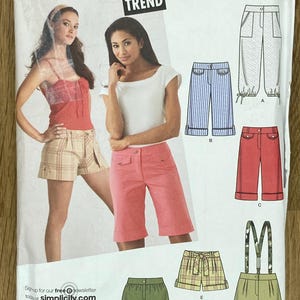 May include: Simplicity sewing pattern with multiple shorts designs. The pattern includes options for shorts with pockets, stripes, and braces. The size range is AA 3/4-9/10. The image also includes the text "JR. TREND" and "Simplicity.com".