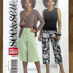 May include: A sewing pattern titled "see & sew" with the number B4962. The pattern features two women modeling different outfits. One outfit includes a light brown cardigan, a ribbed top, and light green culottes. The other outfit includes a black top and black and white floral pants.