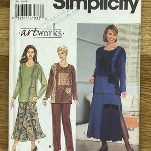 May include: A sewing pattern envelope for a women's clothing pattern. The pattern is for a skirt and top. The envelope is blue and white with the text "Simplicity 8246" and "artworks." printed on it. The pattern is for sizes 12, 14, and 16.