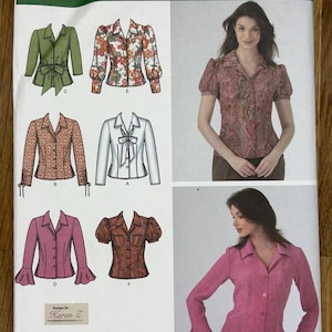 May include: Simplicity sewing pattern 4487 featuring six blouse designs. The pattern includes various styles, such as a green blouse with a tie, a floral print blouse, and a pink blouse with flared sleeves. The pattern size is K5, with measurements in cm.