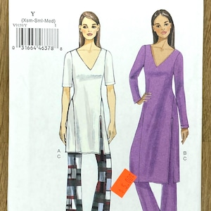 Puede incluir: Un patrón de costura Very Easy Vogue, V9159, con dos mujeres modelando conjuntos de túnica y pantalón. Un conjunto es blanco con pantalones estampados, el otro es morado. El patrón incluye tallas X-Small a Medium.