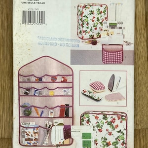 May include: A vintage Butterick sewing pattern, featuring a sewing machine, storage accessories, and a cover with a floral design. The pattern includes a hanging organizer with pockets and a variety of sewing notions.