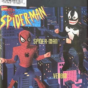 May include: Simplicity Costumes pattern featuring Spider-Man and Venom costumes. The Spider-Man costume is red and blue, while the Venom costume is black and white. The background shows a cityscape.