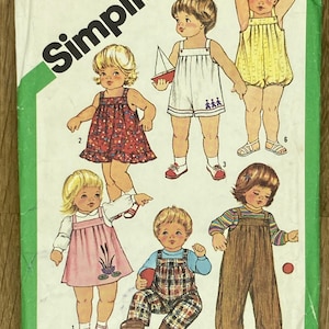Könnte beinhalten: Vintage Simplicity Schnittmuster für Kleidung für Kleinkinder. Das Muster zeigt Illustrationen von Kindern in verschiedenen Outfits, darunter Kleider, Overalls und Shorts. Das Muster enthält den Text "Simplicity" und "Toddler Petit Enfant".