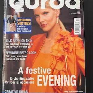 Può includere: Una copertina di rivista di moda "burda" datata dicembre 2003. La copertina presenta una donna in un completo arancione. Il testo include "SWINGING SIXTIES" e "A festive EVENING".