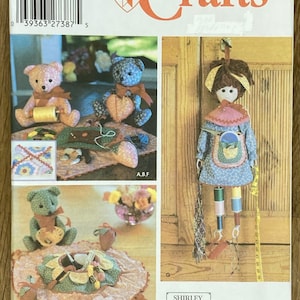 Könnte beinhalten: Simplicity Crafts Schnittmuster mit Teddybären und einer Puppe. Das Schnittmuster enthält Anleitungen zur Herstellung von Stoffhandwerk, wie z. B. Stofftieren und Dekorationsartikeln. Das Cover zeigt mehrere fertige Projekte.