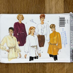 以下が含まれることがあります： 女性用ブラウスとジャケットのイラストが描かれた、Butterickの裁縫パターン封筒。 パターン番号は3701で、サイズは6-8-10です。 封筒には「FAST & EASY CLASSICS」と「FABRICVILLE」の文字があります。