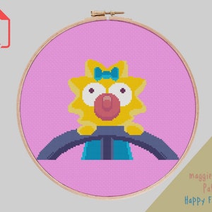 May include: A cross-stitch pattern featuring Maggie Simpson from The Simpsons, driving a car. The pattern is on a pink background and includes the text "Maggie Simpson Pattern Happy Fox Stitch".