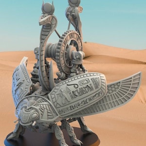 Könnte beinhalten: Detaillierte, graue Skulptur eines ägyptischen Skarabäus-Käfers mit Hieroglyphen auf den Flügeln. Die Skulptur zeigt eine Kobra und andere ägyptische Motive, vor einer Wüstenkulisse. Der Käfer steht auf einem schwarzen Sockel.