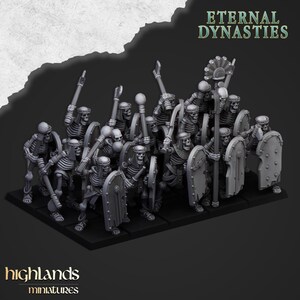 Può includere: Un gruppo di miniature grigie di guerrieri scheletri, armati di lance, mazze e scudi. Le miniature sono disposte su una base nera, con il testo "Eternal Dynasties" e "highlands miniatures".