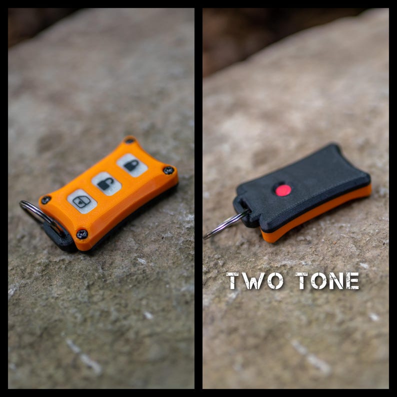 May include: A two-tone key fob cover featuring an orange front with three white buttons displaying lock, unlock, and boot icons, secured by four black screws. The reverse side is black with a single red circular button and a metal key ring.