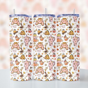 Könnte beinhalten: Drei Edelstahlbecher mit weißem Hintergrund und einem Muster aus rosa Pullovern, Tassen mit heißen Getränken und Herbstmotiven. Der Text "Welcome Fall" wird im gesamten Muster wiederholt.