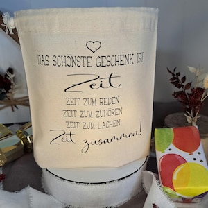 Könnte beinhalten: Eine weiße Stofftasche mit einem schwarzen Herz und dem Text "Das schönste Geschenk ist Zeit" und "Zeit zum Reden, Zeit zum Zuhören, Zeit zum Lachen, Zeit zusammen!"