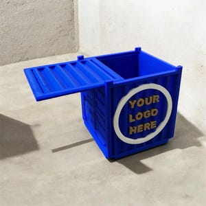 May include: A blue container-shaped box with a hinged lid. The box has a white circle with the text "YOUR LOGO HERE" in gold. The box is sitting on a gray surface.