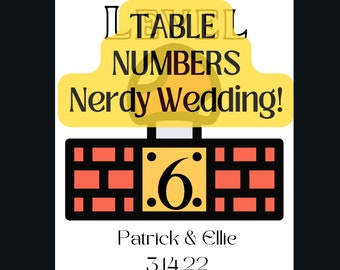 Könnte beinhalten: Eine gelbe und schwarze Tischnummernkarte mit dem Text "Level Numbers Nerdy Wedding!" und der Nummer 6 in einem Ziegelrahmen. Der Text "Patrick & Ellie 3.14.22" befindet sich unter dem Rahmen.