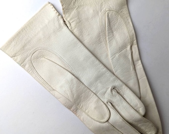 May include: A pair of white leather gloves with a stitched seam detail.