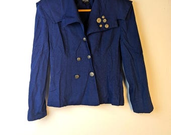 May include: A navy blue blazer with a double breasted closure and decorative buttons. The blazer has a wide collar and a slightly fitted silhouette.