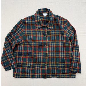 May include: A long-sleeved button-down shirt featuring a dark green, red, and yellow plaid pattern. The shirt has a standard collar, a front button closure, and two square patch pockets at the bottom front. A white brand label is visible at the neck.
