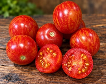 May include: A collection of round, red cherry tomatoes with distinct yellow-orange vertical stripes. Several tomatoes are whole, while two are sliced in half, revealing the moist, seeded interior flesh and a vibrant red color.