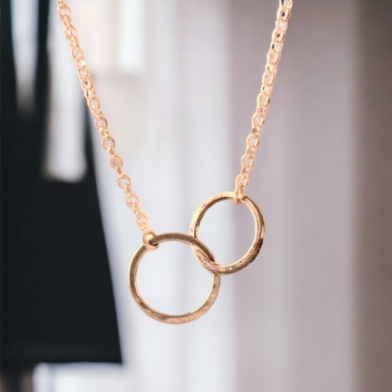 A minimalist sterling silver necklace with two connected circles. This is a unity necklace.