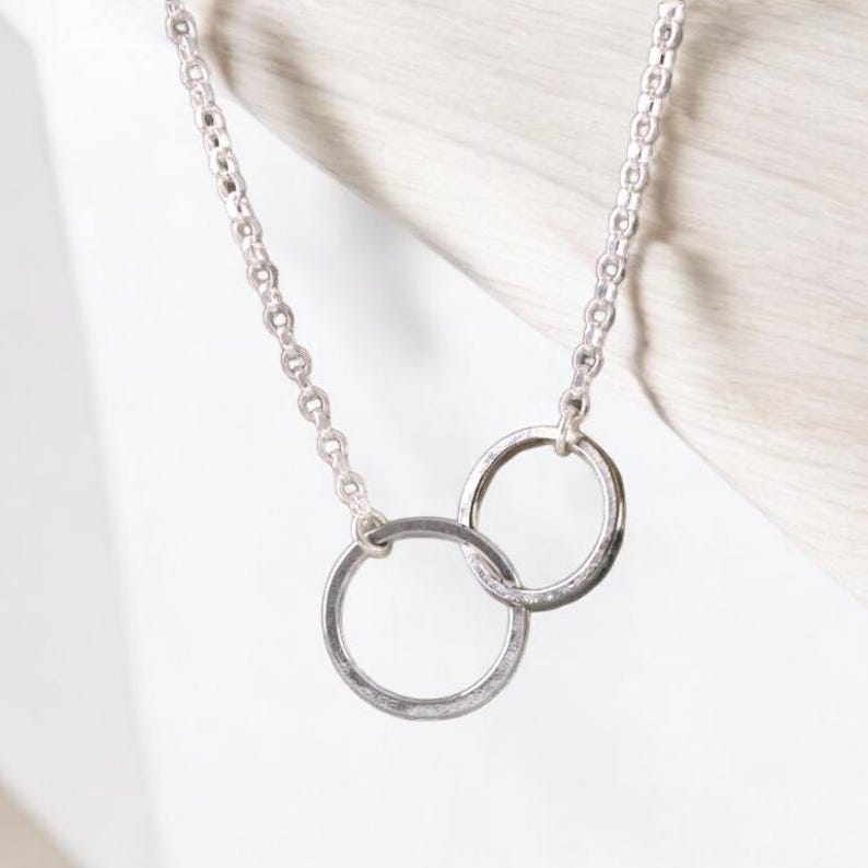A minimalist sterling silver necklace with two connected circles. This is a unity necklace.