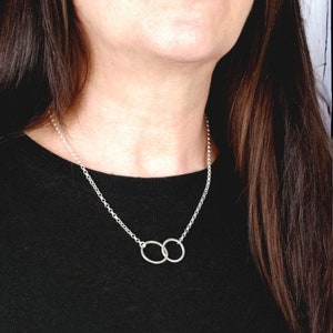 A minimalist sterling silver necklace with two connected circles. This is a unity necklace.