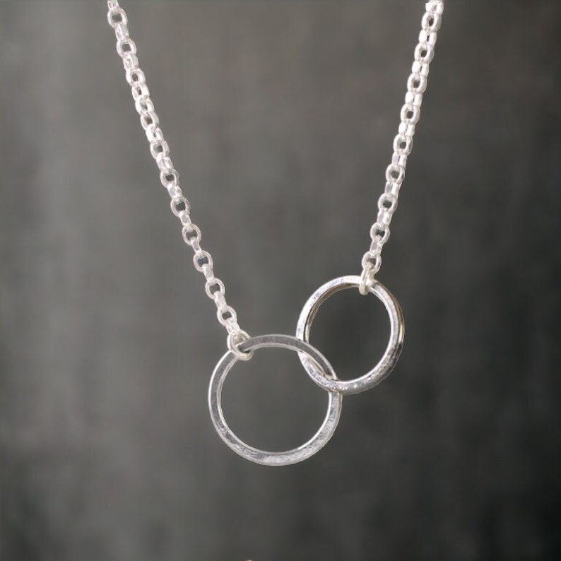 A minimalist sterling silver necklace with two connected circles. This is a unity necklace.