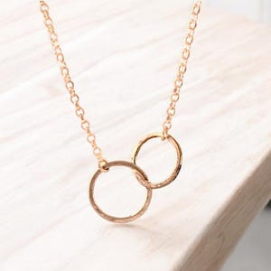 A minimalist sterling silver necklace with two connected circles. This is a unity necklace.