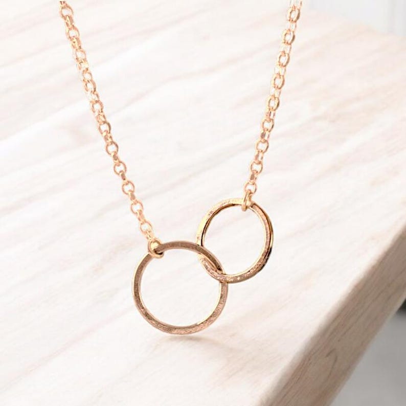 A minimalist sterling silver necklace with two connected circles. This is a unity necklace.