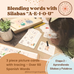 May include: A child is learning Spanish by blending syllables with picture cards. The cards feature colorful illustrations and the words "paia ri", "piña ta", "piñato", "si lla", and "silla". The text on the cards reads "Blending words with Silabas "A-E-I-O-U"" and "Etapa 2 - Aprendiendo Silabas y Palabras".