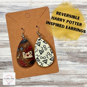 Op de afbeelding: Reversible Harry Potter geïnspireerde oorbellen. De ene kant heeft een bruine achtergrond met Harry Potter-thema afbeeldingen, waaronder een bril, een veer, een sleutel en een brief. De andere kant heeft een witte achtergrond met een herhalend patroon van het Doodsmerk symbool en een bril.