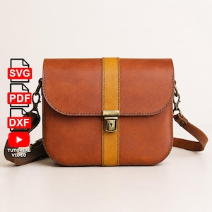 May include: A brown leather crossbody bag with a vertical yellow stripe down the center. The bag has a flap closure with a metal clasp and a long adjustable strap. The bag has a rectangular shape with rounded corners.