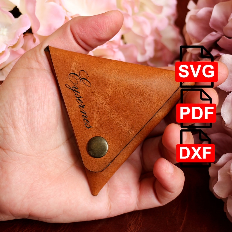 Pode incluir: Uma carteira de moedas de couro marrom com formato triangular e fecho de press&atilde;o. A carteira tem a palavra "Eysernes" gravada. A imagem tamb&eacute;m mostra os formatos de arquivo dispon&iacute;veis para download: SVG, PDF e DXF.