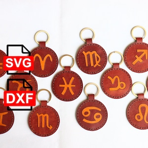 May include: Twelve leather keychains with different zodiac signs in orange on a white background. The keychains are labeled with the file types SVG and DXF.