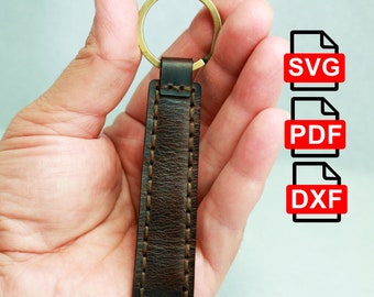 May include: A brown leather keychain with a brass ring. The rectangular leather piece is stitched with brown thread. The image also includes three file type icons: SVG, PDF, and DXF.